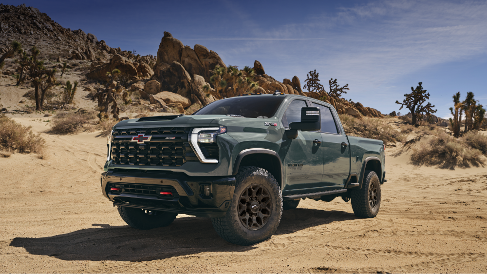 A Chevy Silverado HD Driving Across a Sandy Off-Road Desert Landscape Surrounded by Rocky Terrain and Desert Vegetation