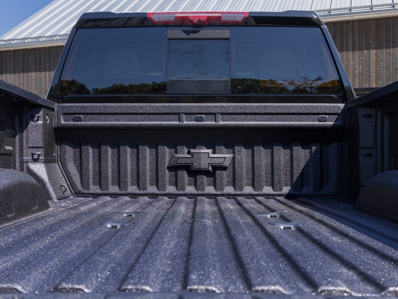 A Close-Up View of the Durable Durabed Truck Bed in a Chevy Silverado HD With the Tailgate Lowered and the Text “DURABED” Displayed Across the Bottom
