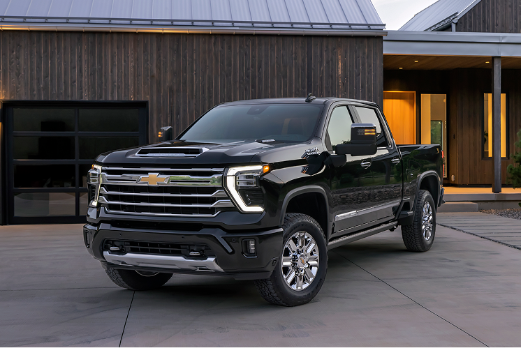 Front Three-Quarter View of a Black Chevrolet Silverado HD High Country Parked in a Modern Residential Driveway With Premium Exterior Styling and Chrome Accents.