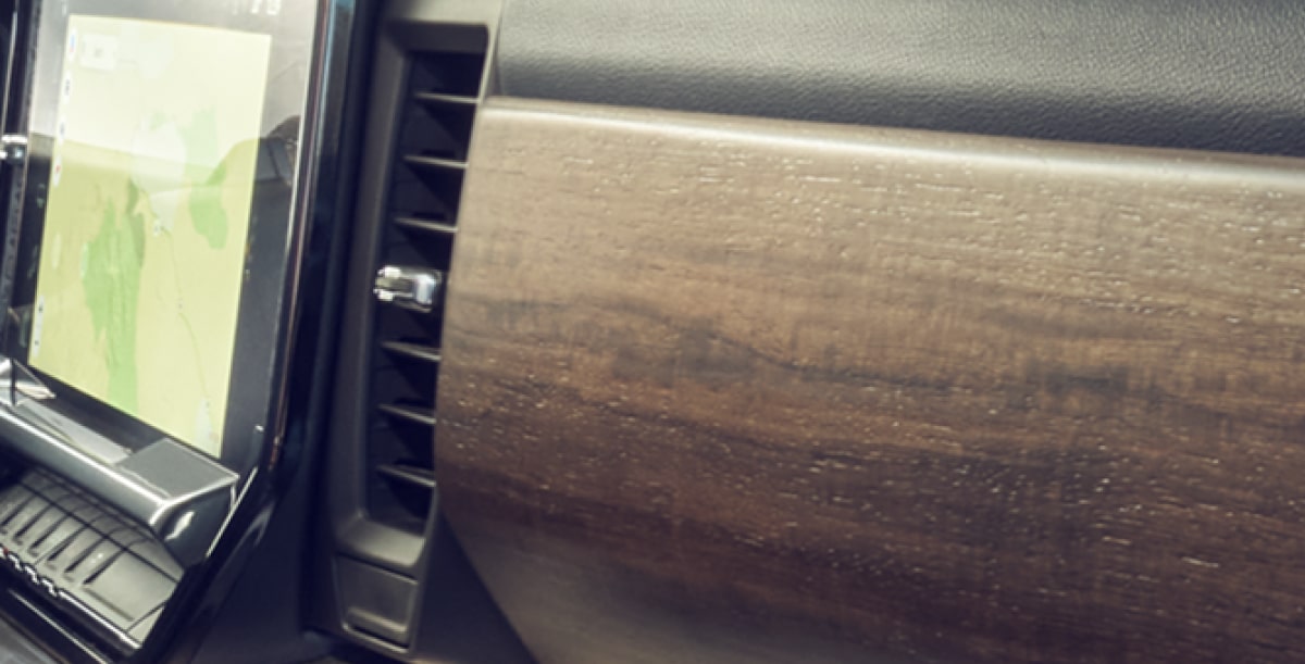 Close-Up of an Interior Dashboard Featuring Authentic Wood Trim Accents Adjacent to a Center Touchscreen Display.