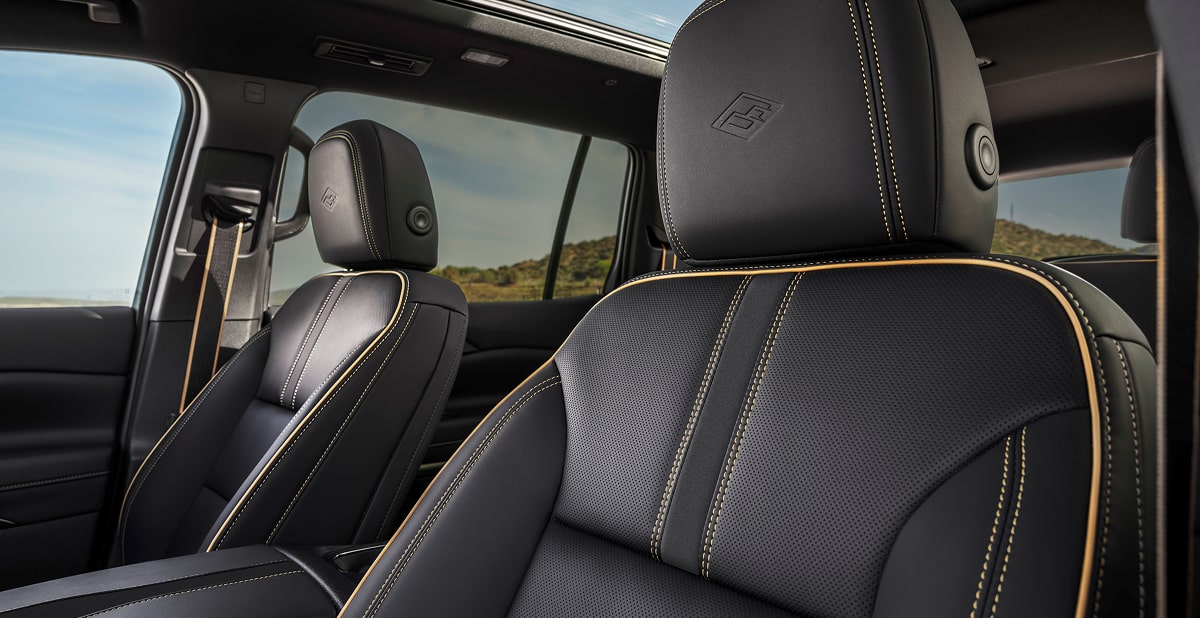 Premium Black Leather Front Seats Featuring High Country Embossed Headrests, Contrast Stitching, and a Panoramic Sunroof.