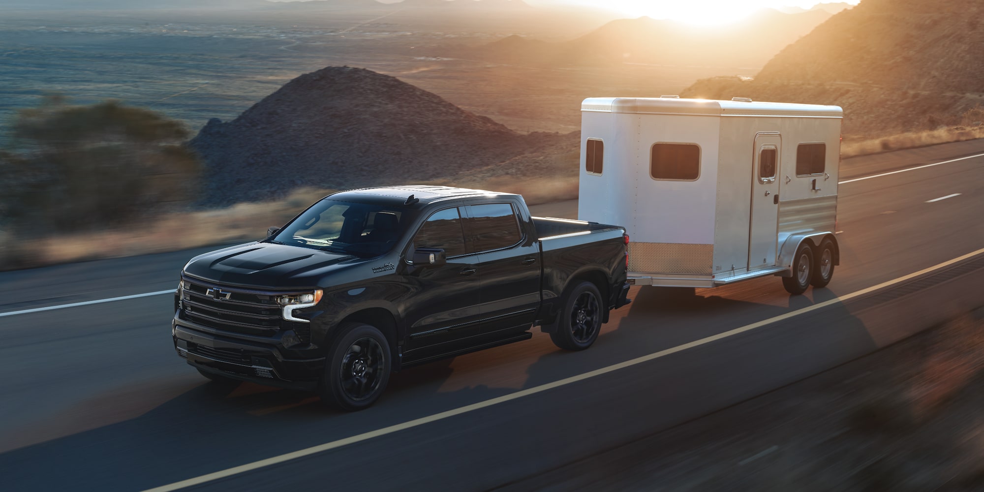 2025 Chevy Silverado LD Towing a Small Trailer on a Highway