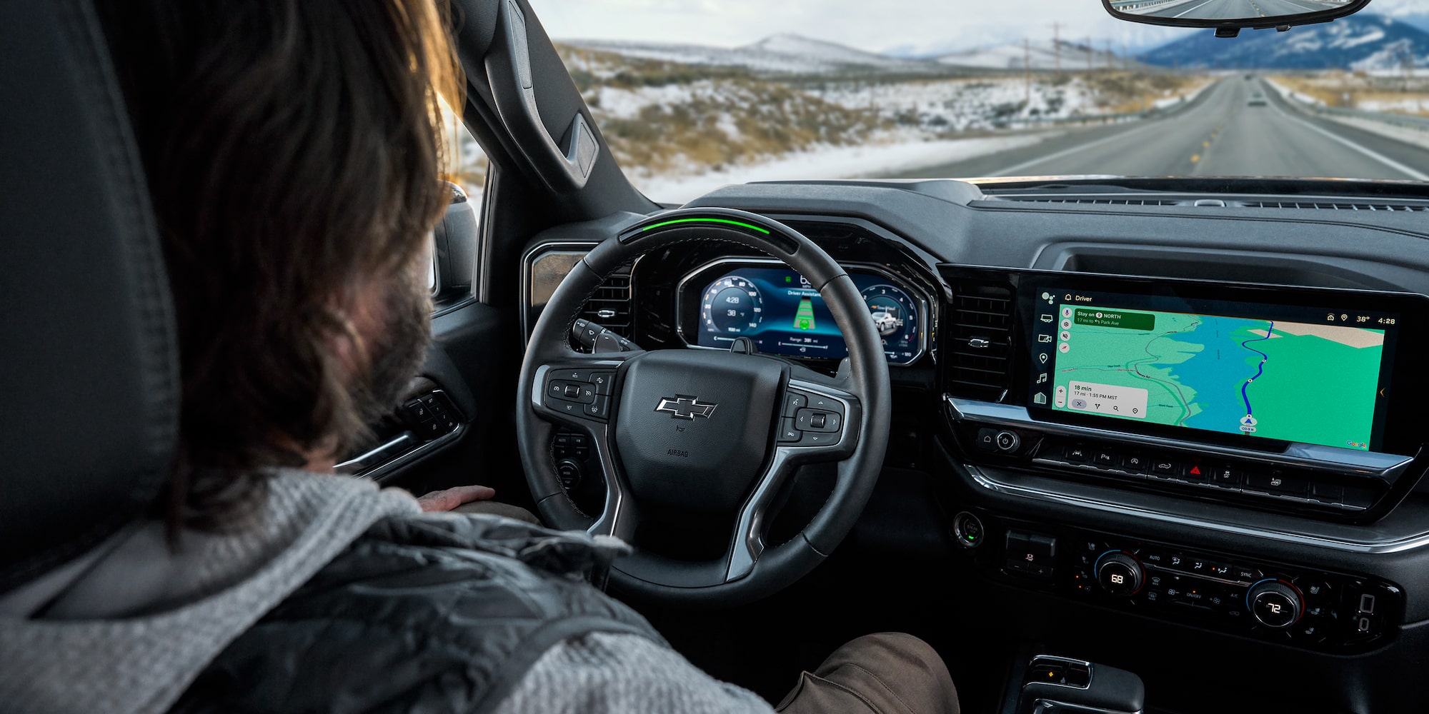 Man In Driver's Seat of Chevy Silverado Looking at Interior Dashboard
