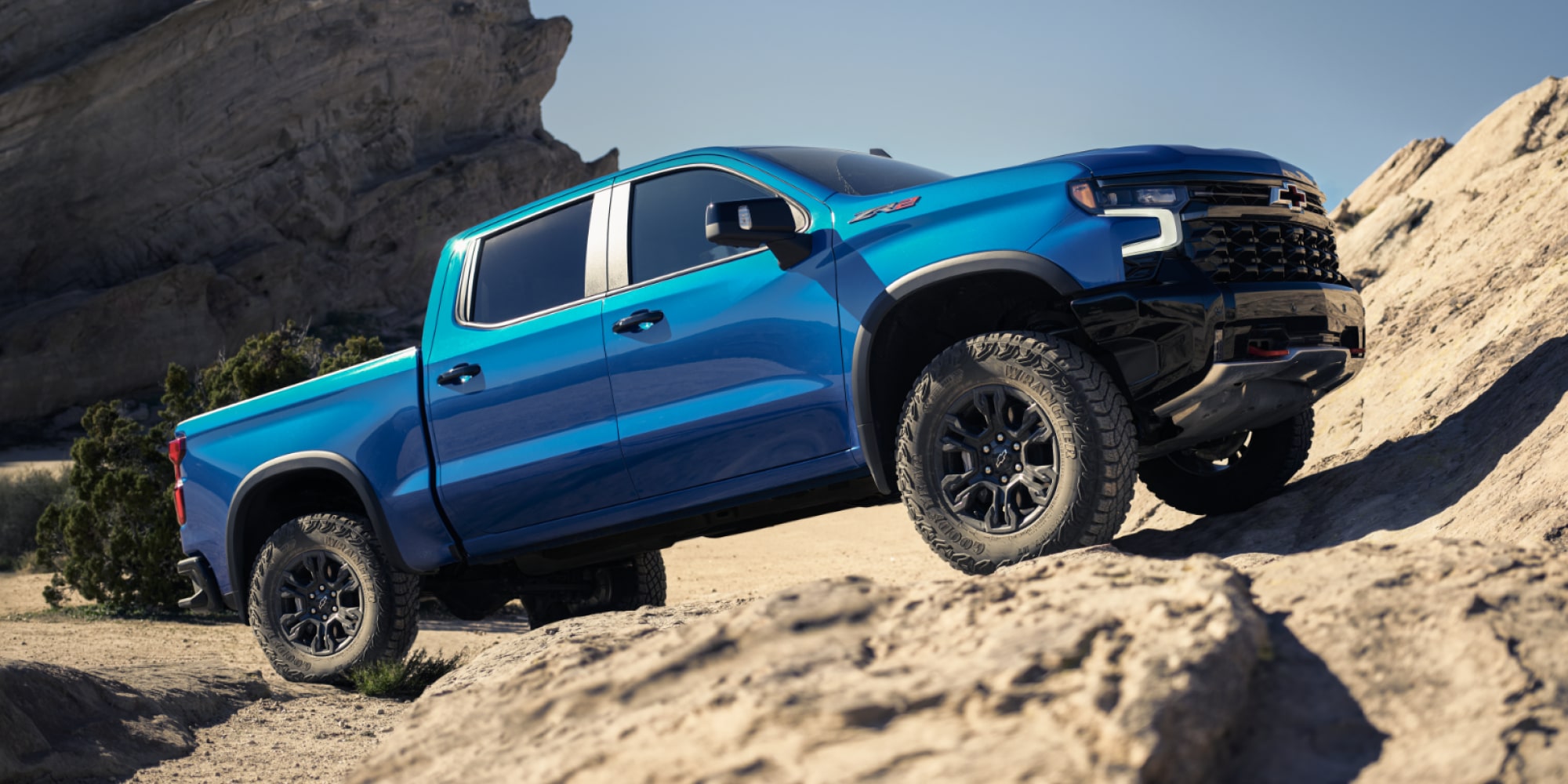 A Blue Chevy Silverado 1500 Pickup Truck Off-Roading on Mountain Hills.