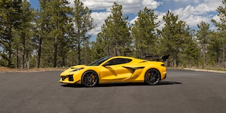Side View of a Yellow Chevy Corvette ZR1 beside Trees under a Beautiful Blue Sky with Clouds