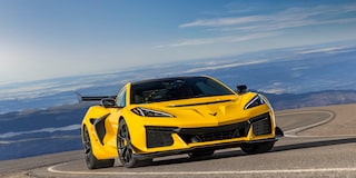 Low Angle Three Quarters View of a Yellow Chevy Corvette ZR1 Going down a Road with a Clear Blue Sky