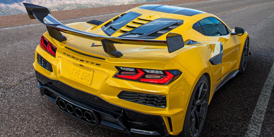 Three Quarters Rear View of a Yellow Chevy Corvette ZR1 Driving Down the Road with a Blue Sky