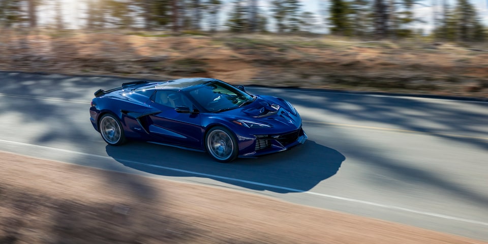 A Blue Chevy Corvette ZR1 Driving Down the Road with Trees on the Side