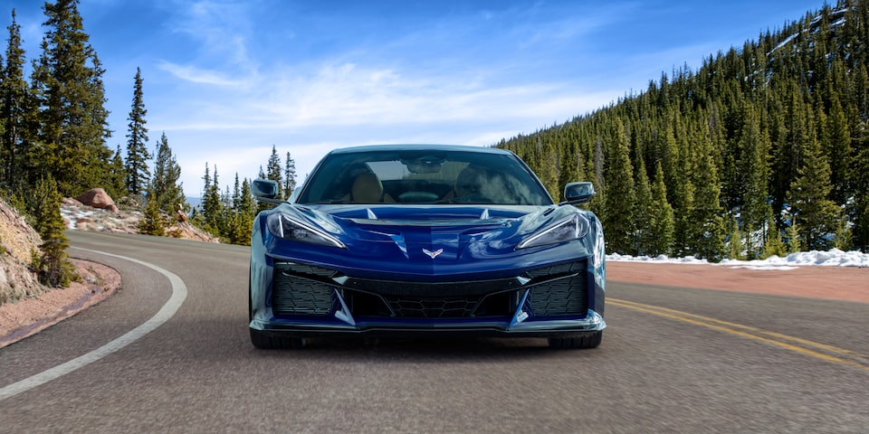 Front View of a Blue Chevy Corvette ZR1 Driving Down the Road with a Blue Sky
