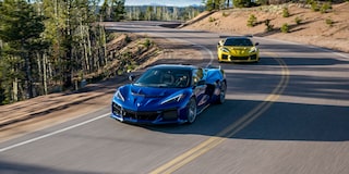 Two Blue and Yellow Chevy Corvette ZR1 Racing Down a Road under on a Sunny Day