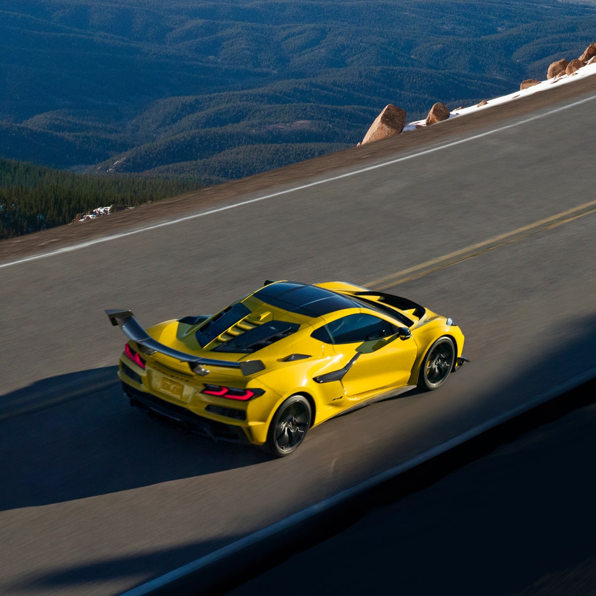 Vista aérea de un Chevy Corvette ZR1 amarillo circulando por un camino