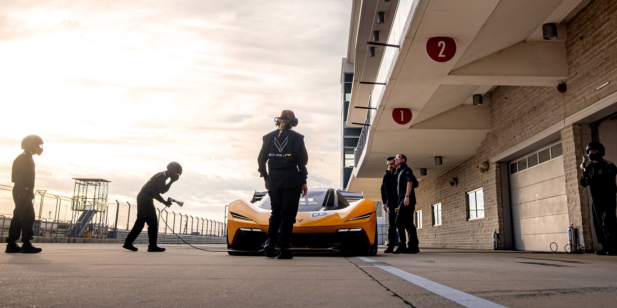 Front view of a 2026 Corvette CX.R on a track surrounded by a pit crew