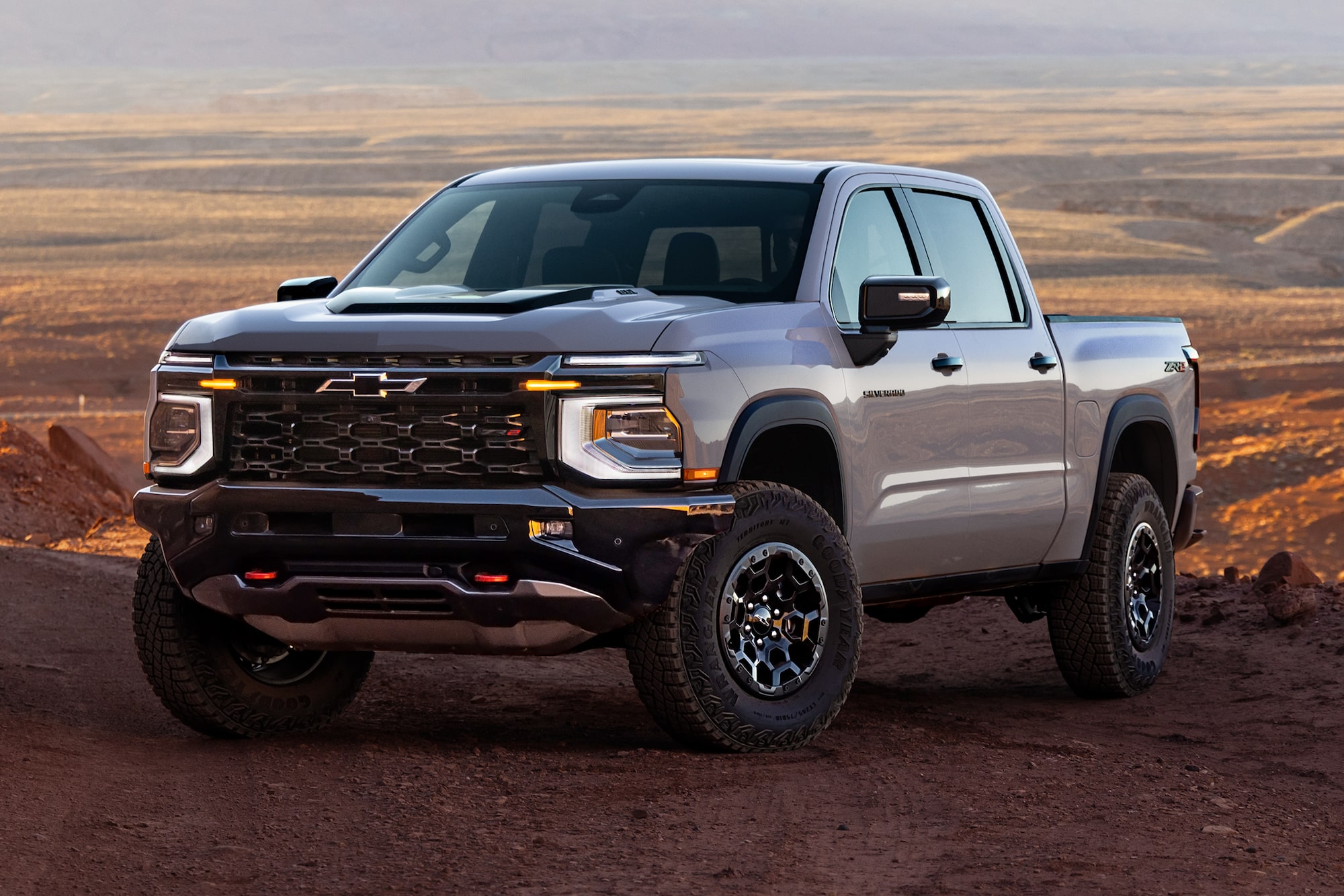 Vista de tres cuartos de Chevy Silverado 1500 2027 estacionada en un desierto abierto