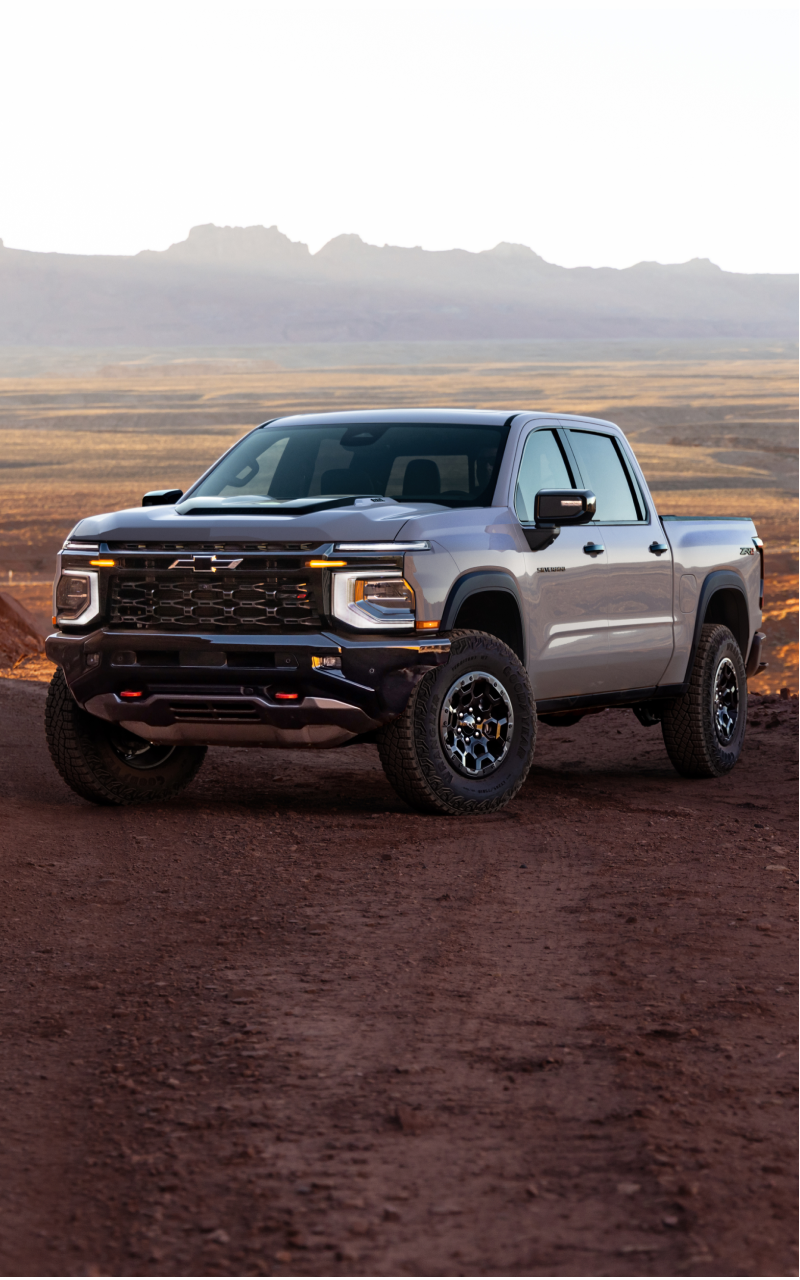 Three-quarters View of a 2027 Chevy Silverado 1500 Parked in an Open Desert with Text Overlay Reading "Rugged and ready for anything."