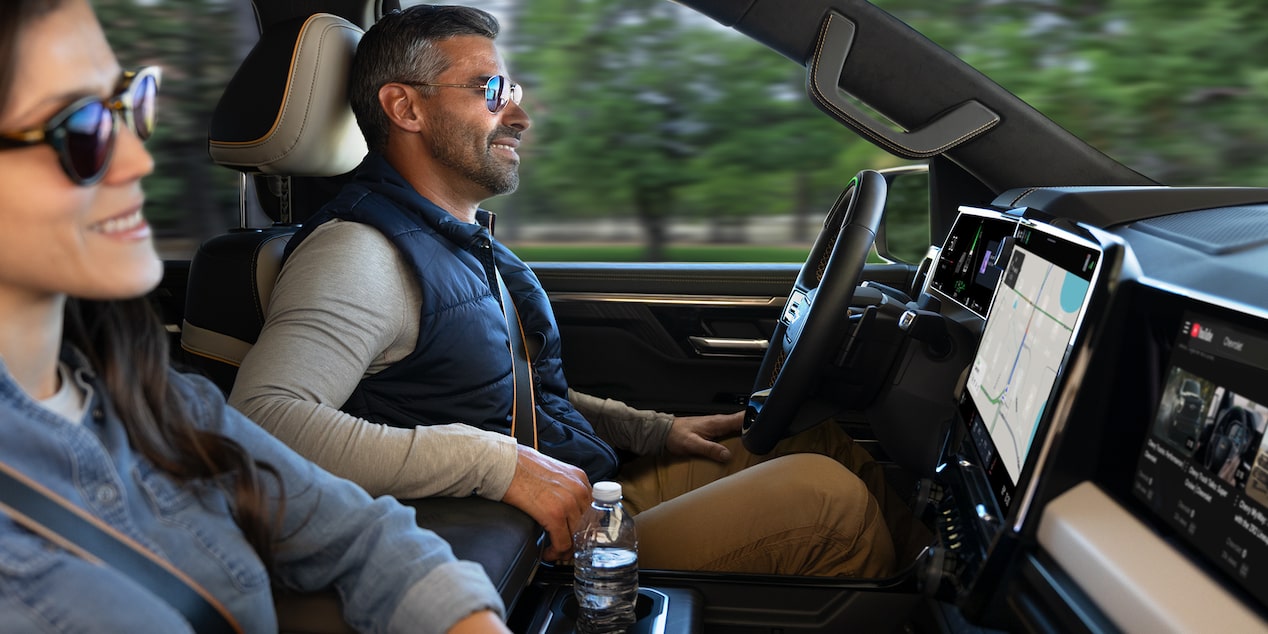 Passenger Seat View of a Man Smiling and Utilizing the Super Cruise Hands-free Technology While Driving a Chevy Silverado