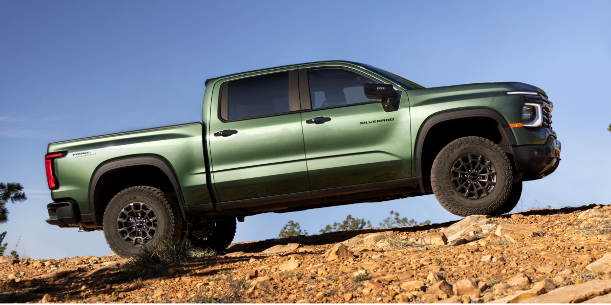 A Green 2027 Chevy Silverado 1500 Off-roading on a Rugged, Rocky Hill