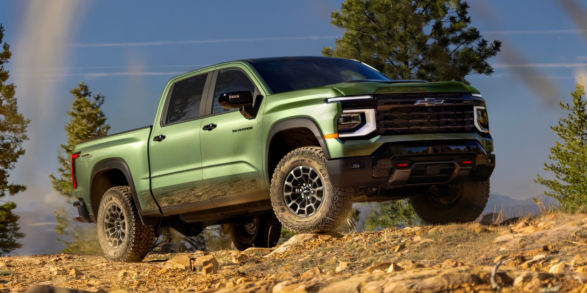 A Green 2027 Chevy Silverado 1500 Off-roading on a Rugged, Rocky Hill