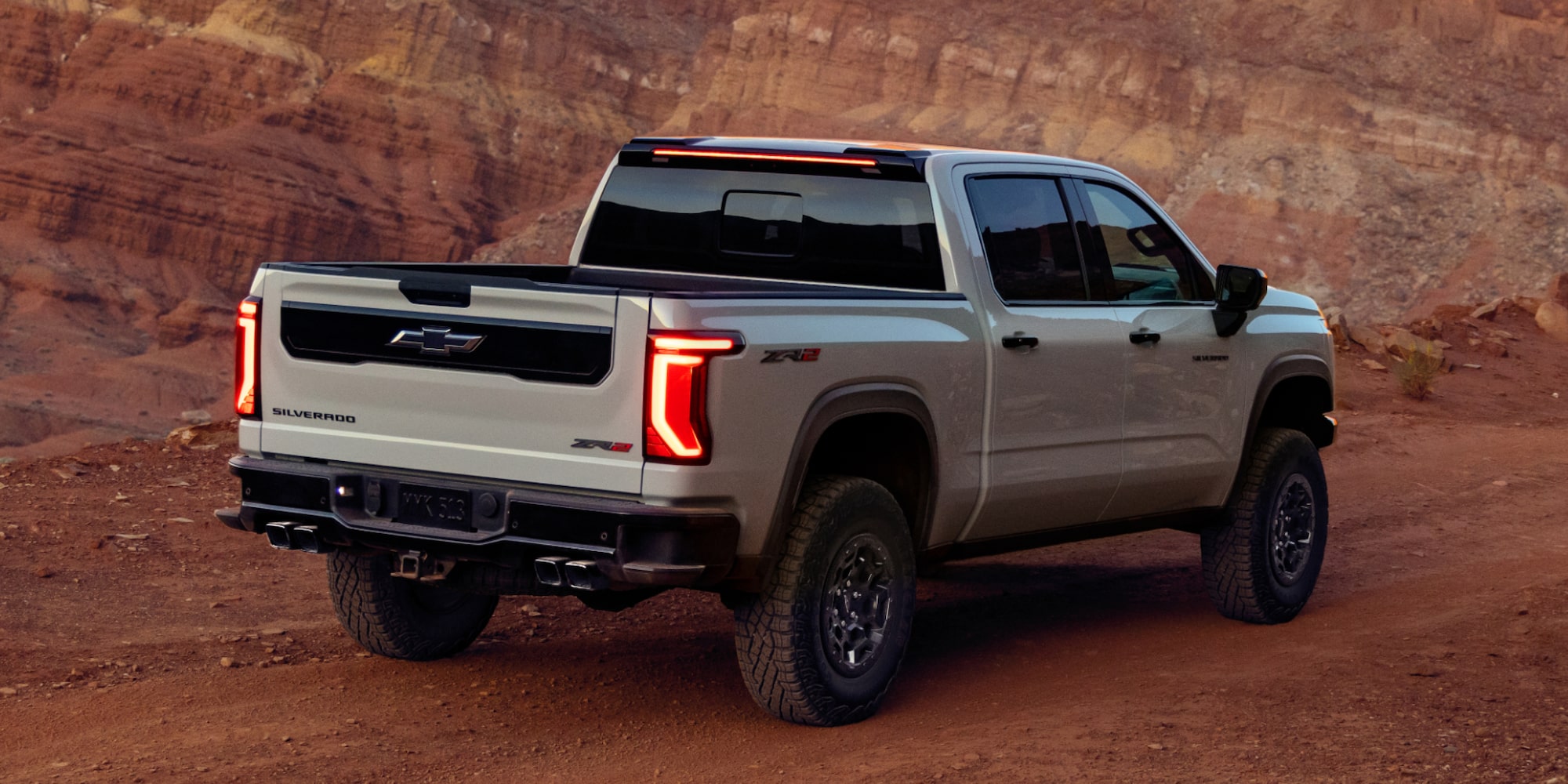Rear Three-quarters View of a 2027 Chevy Silverado 1500 Off-roading on a Canyon, Desert Road