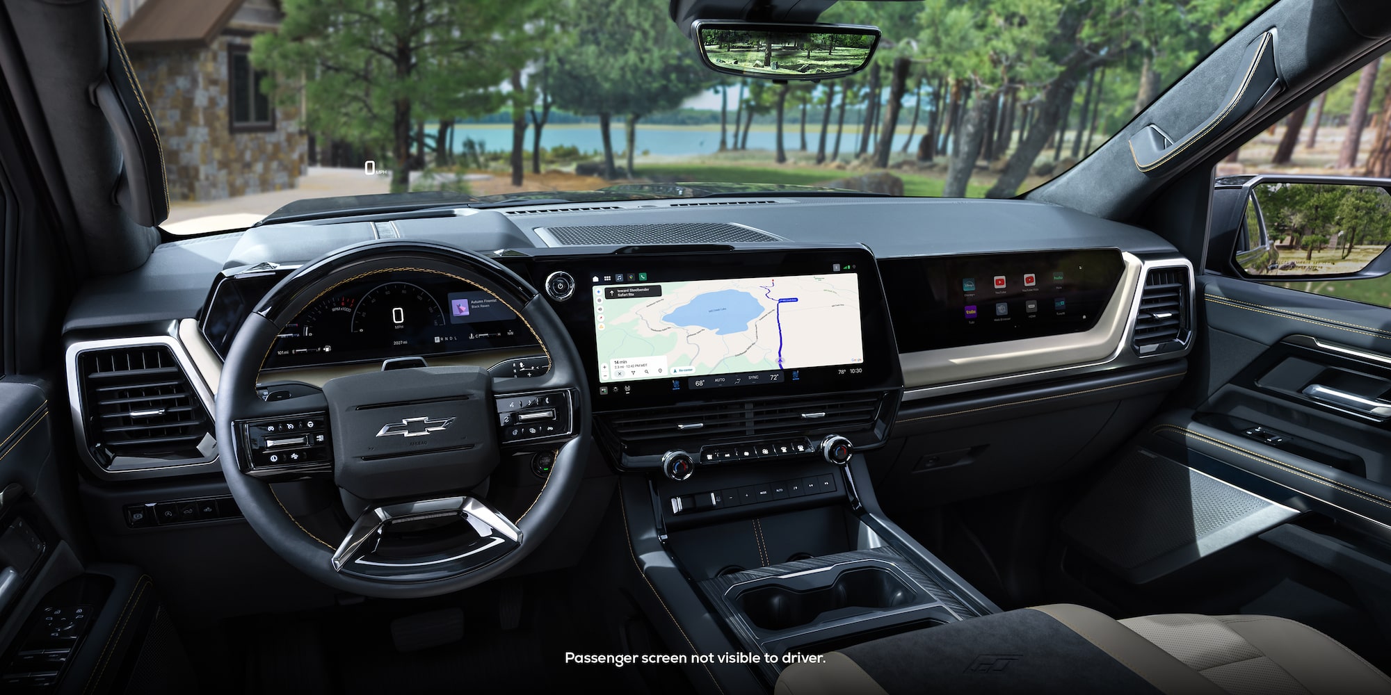 Driver Seat View of the 2027 Chevy Silverado 1500 Front Row Cabin Interior and Dashboard While Outlooking Trees Lining a Lake