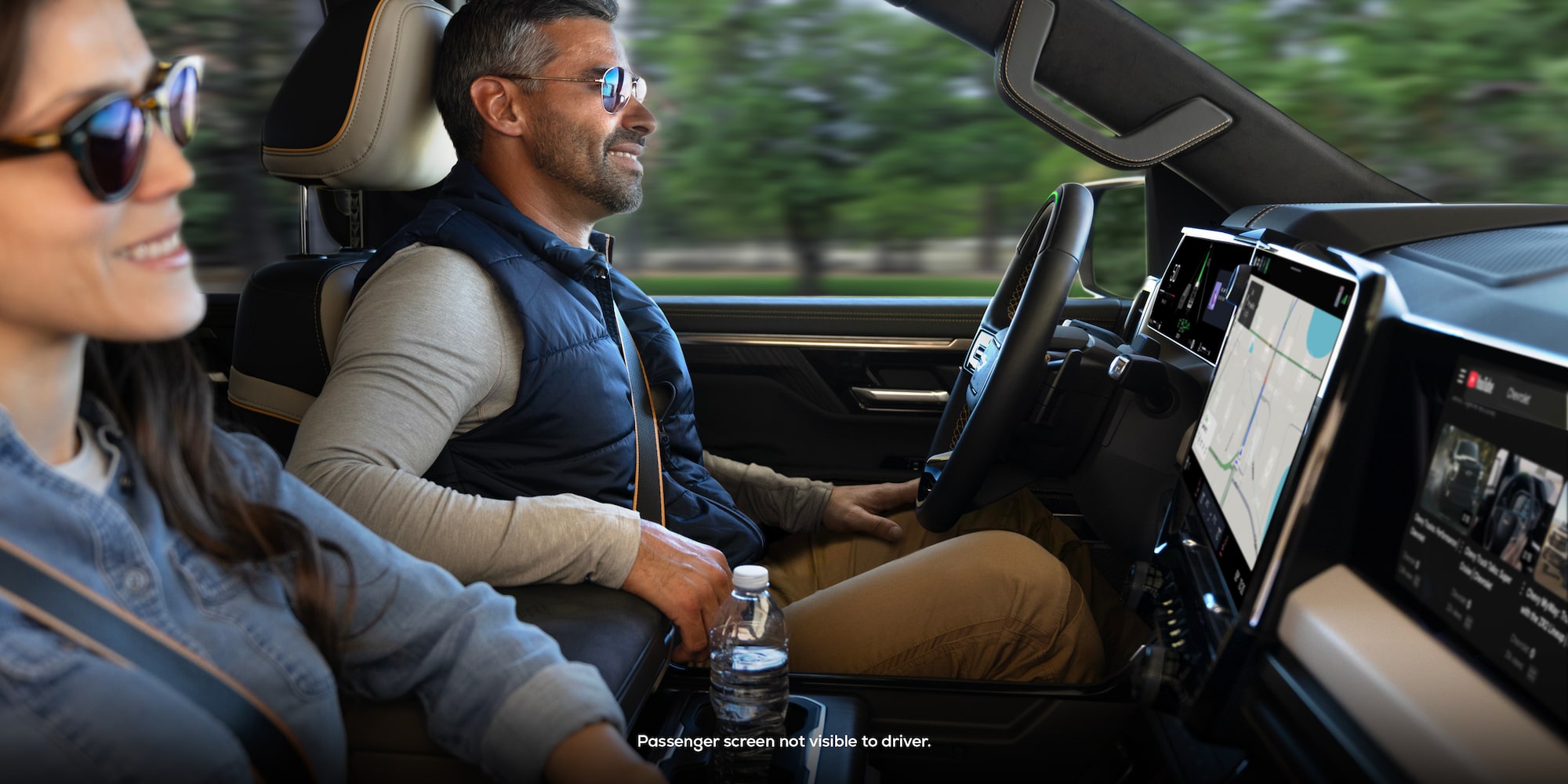Passenger Seat View of a Man Smiling and Utilizing the Super Cruise Hands-free Technology While Driving a Chevy Silverado