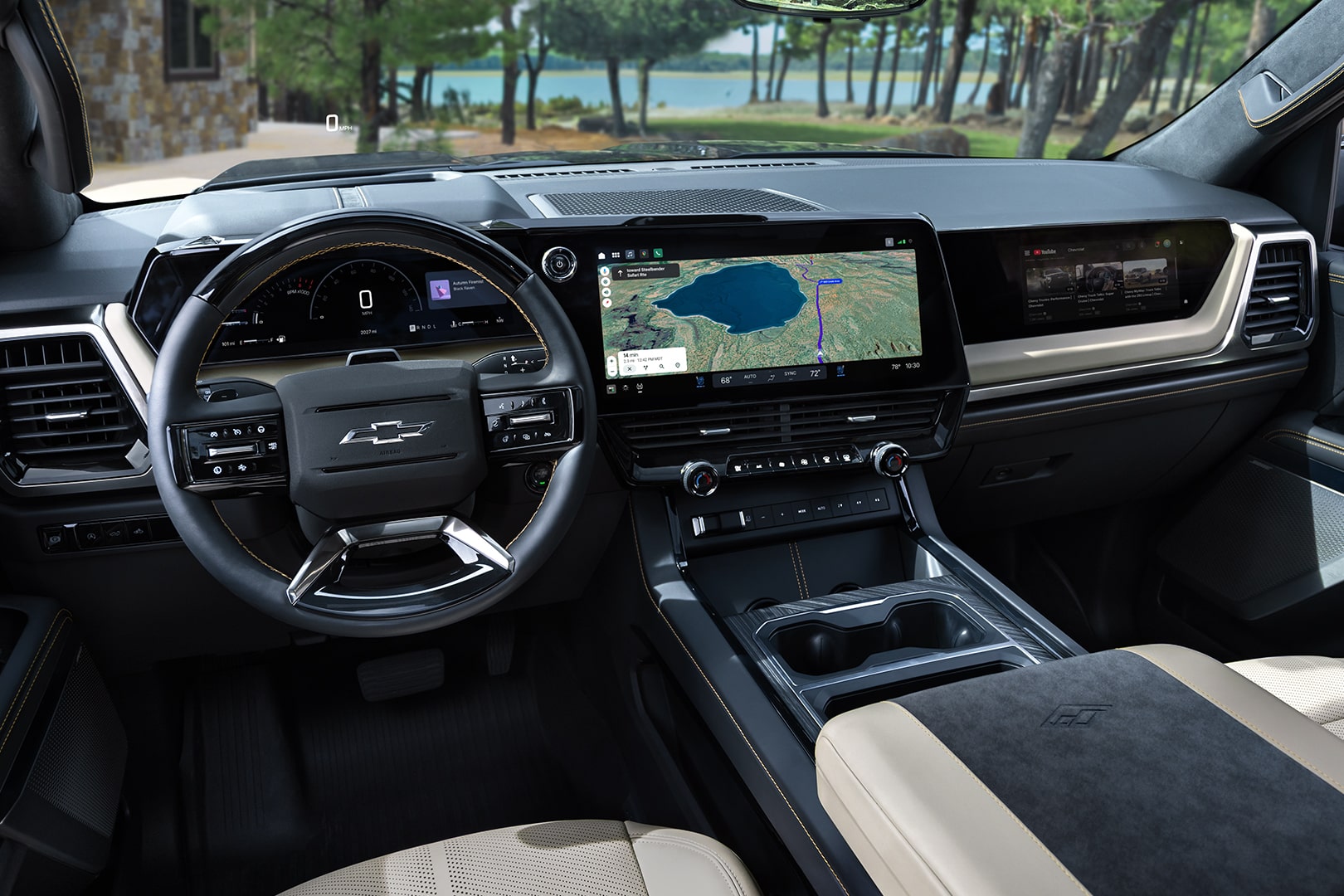 Driver Seat View of the 2027 Chevy Silverado 1500 Front Row Cabin Interior and Dashboard While Outlooking Trees Lining a Lake
