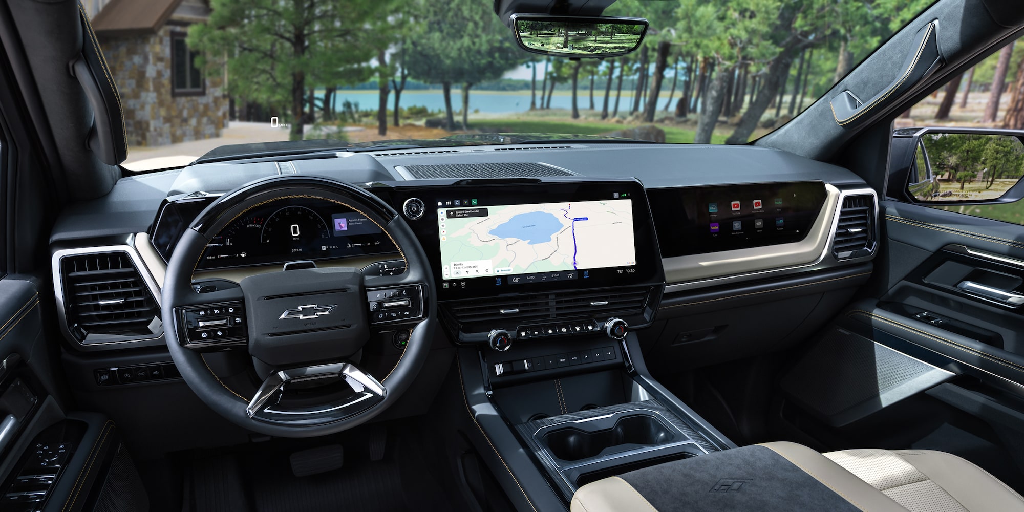 Driver Seat View of the 2027 Chevy Silverado 1500 Front Row Cabin Interior and Dashboard While Outlooking Trees Lining a Lake