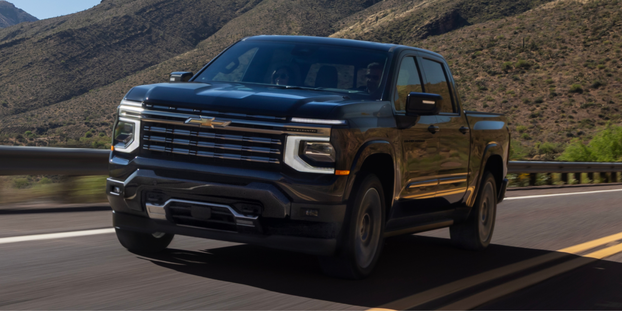 Illustrative: a dark Chevrolet Silverado 1500 High Country driving on a desert highway