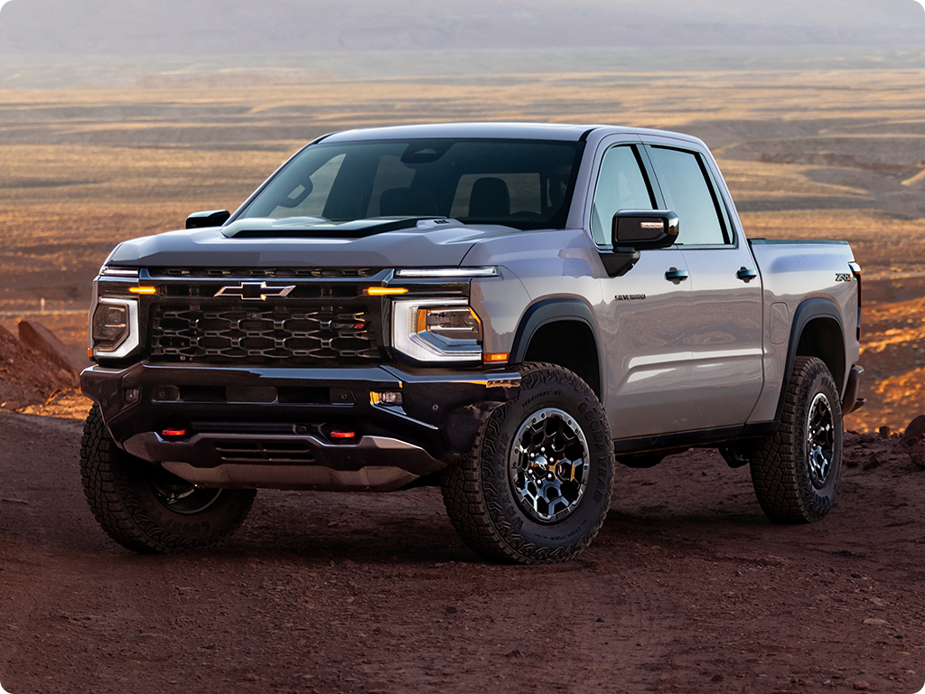 Three-quarters View of a 2027 Chevy Silverado 1500 Parked in an Open Desert with Text Overlay Reading "ZR2"
