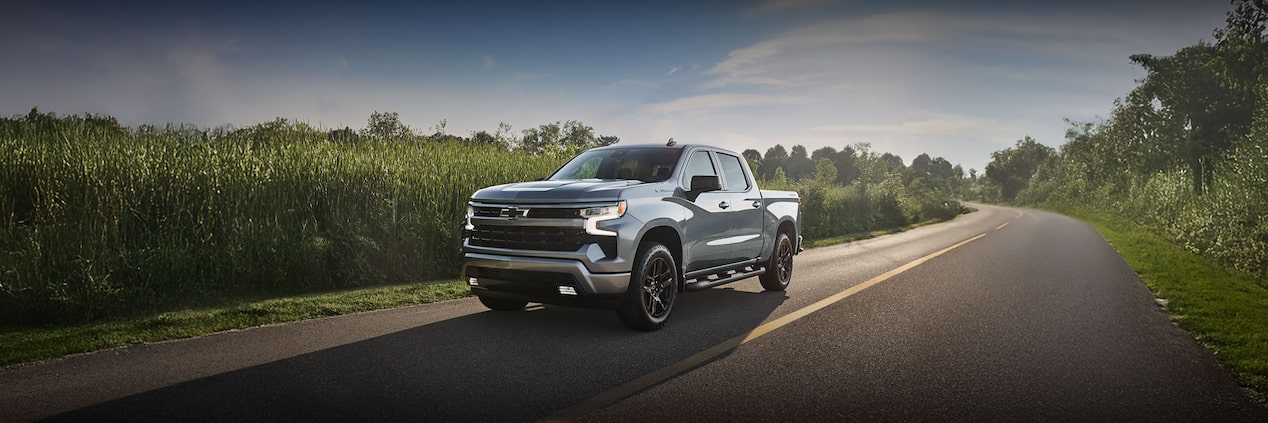 Chevrolet Silverado driving on a tree-lined road
