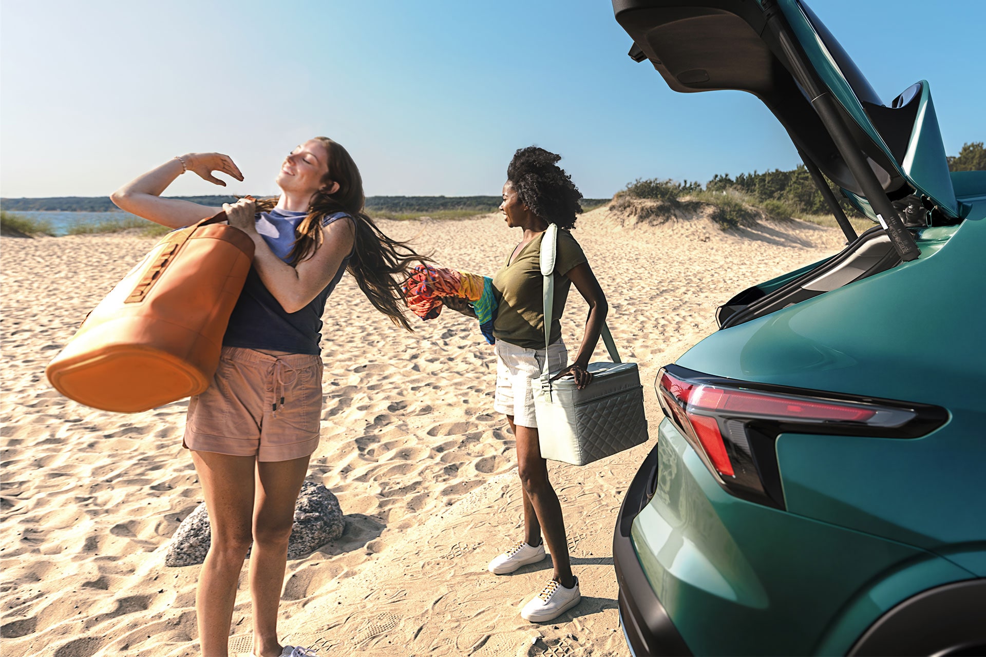 A Chevy Trax Parked on a Sandy Beach With Beach Bags and Gear Being Removed From the Open Rear Cargo Area.