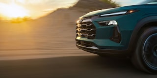 A Close-Up of the Side and Headlight of a Chevy Trax Driving at Sunset.