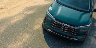 An Elevated Front Three-Quarter View of a Chevy Trax Parked Beside a Sandy Beach Road.