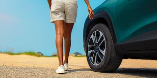 A Close-Up of a Person Walking Beside a Chevy Trax Showing the Rear Wheel and Lower Body Styling.