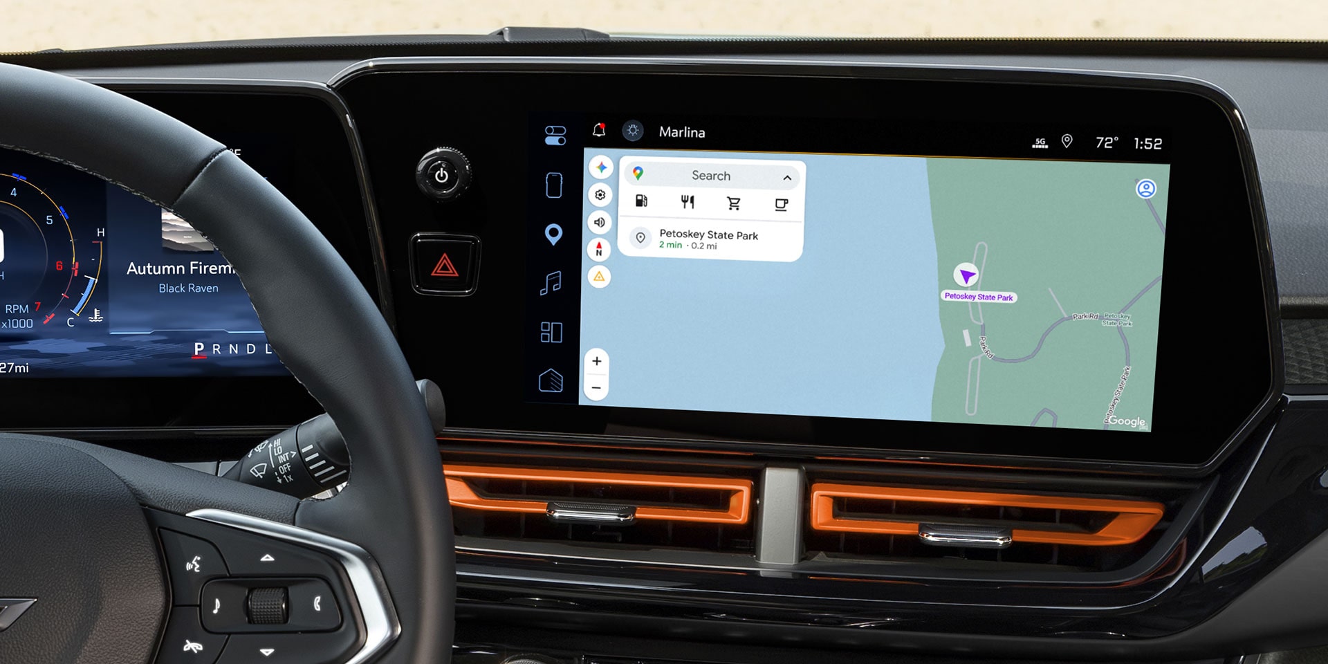 A Wide View of the Chevy Trax Interior Featuring the Steering Wheel, Digital Driver Display, Infotainment Touchscreen, and Front Cabin Controls.