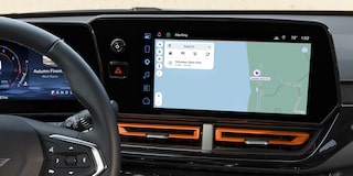 A Wide View of the Chevy Trax Interior Featuring the Steering Wheel, Digital Driver Display, Infotainment Touchscreen, and Front Cabin Controls.