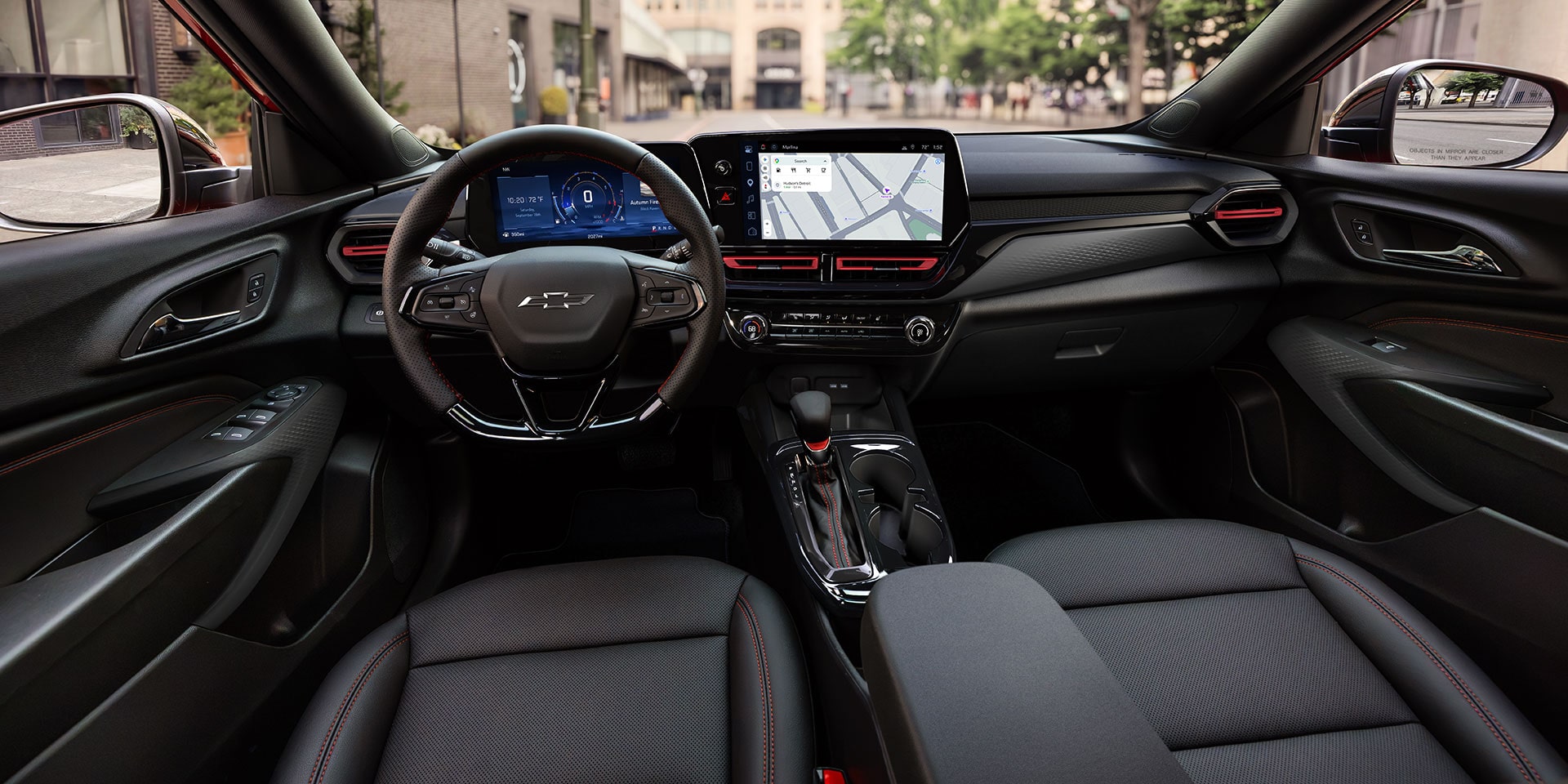 A Wide View of the Chevy Trax Interior Showing the Steering Wheel, Digital Displays, Front Seats, and Center Console.