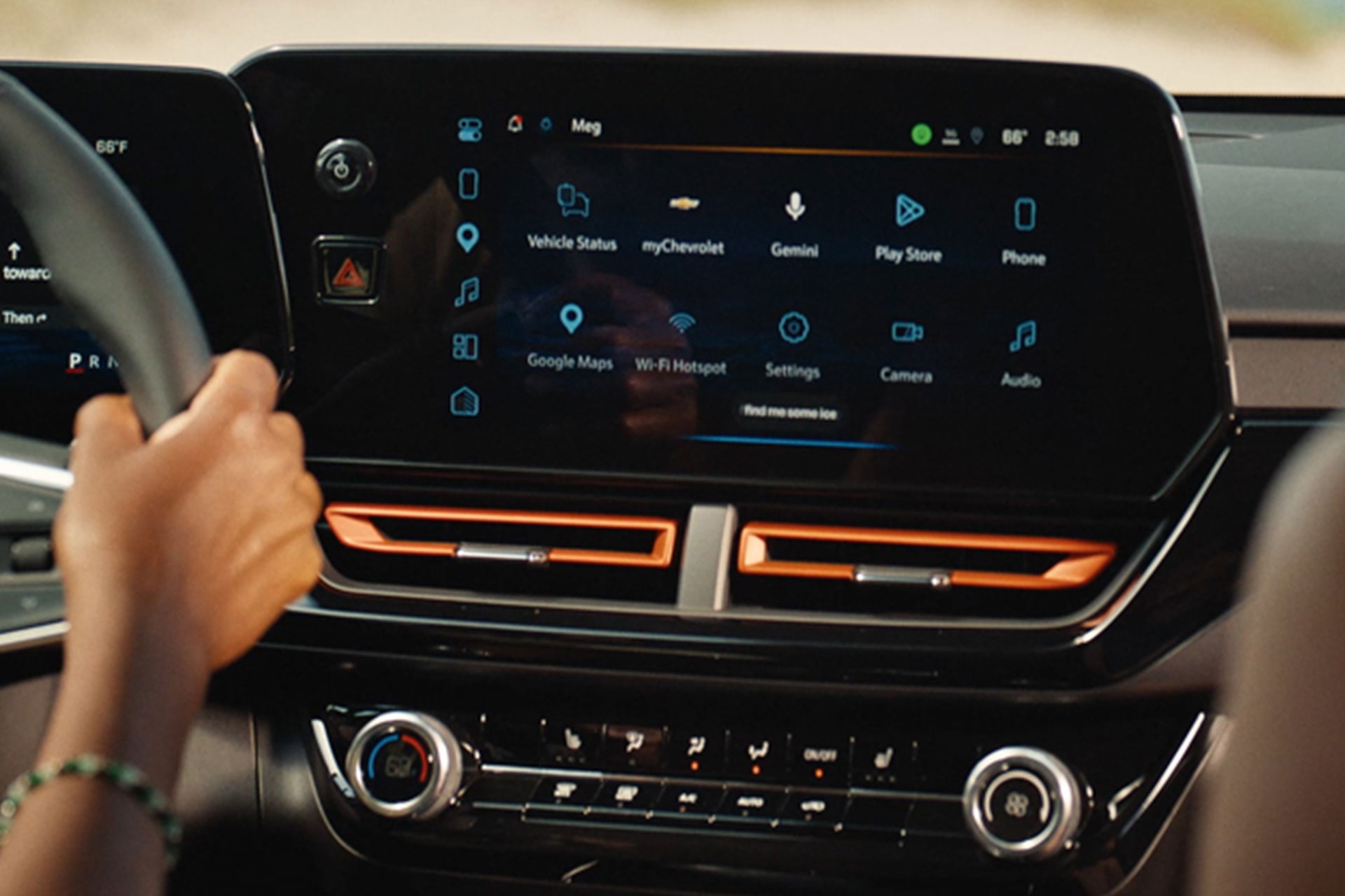 A Close-Up of the Chevy Trax Infotainment System Showing Navigation Features Above Orange Dashboard Accents and Climate Controls.