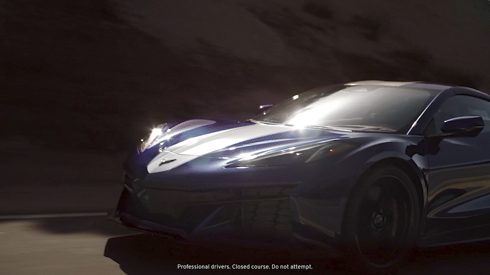 Un Chevrolet Corvette Grand Sport circulando por un camino soleado con las sombras que proyecta su carrocería.