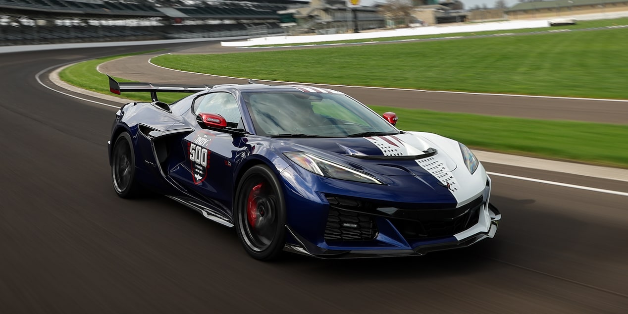 A Dark Blue and White Chevy Corvette ZR1X with the Side Reading "Indy 500" Speeding Down the Curve of a Racetrack