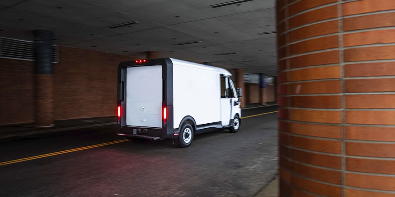 Una van BrightDrop estacionada en una zona de carga de un edificio