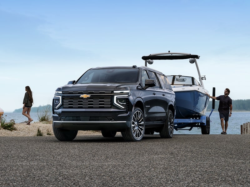 Black 2026 Chevrolet Suburban towing boat