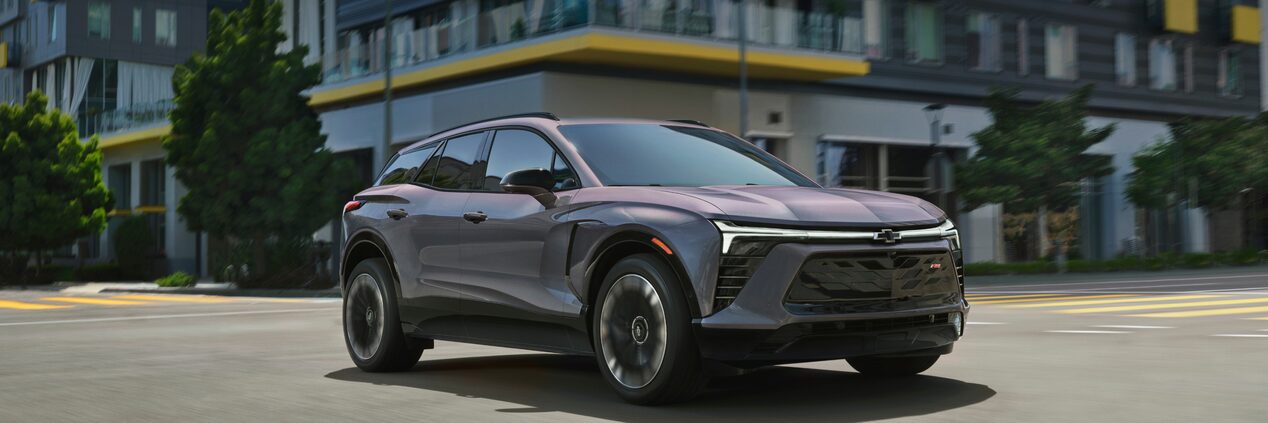 Grey Blazer EV Driving on City Street