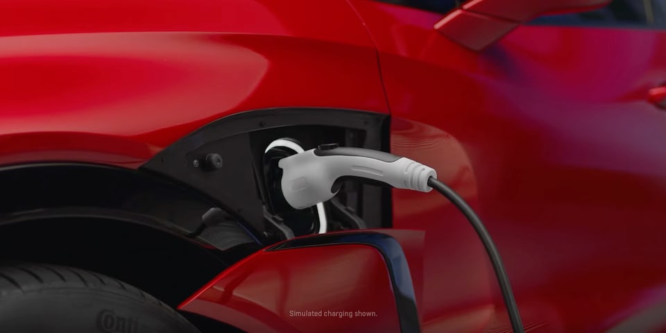 Una Blazer EV roja estacionada en el garaje y enchufada al cargador