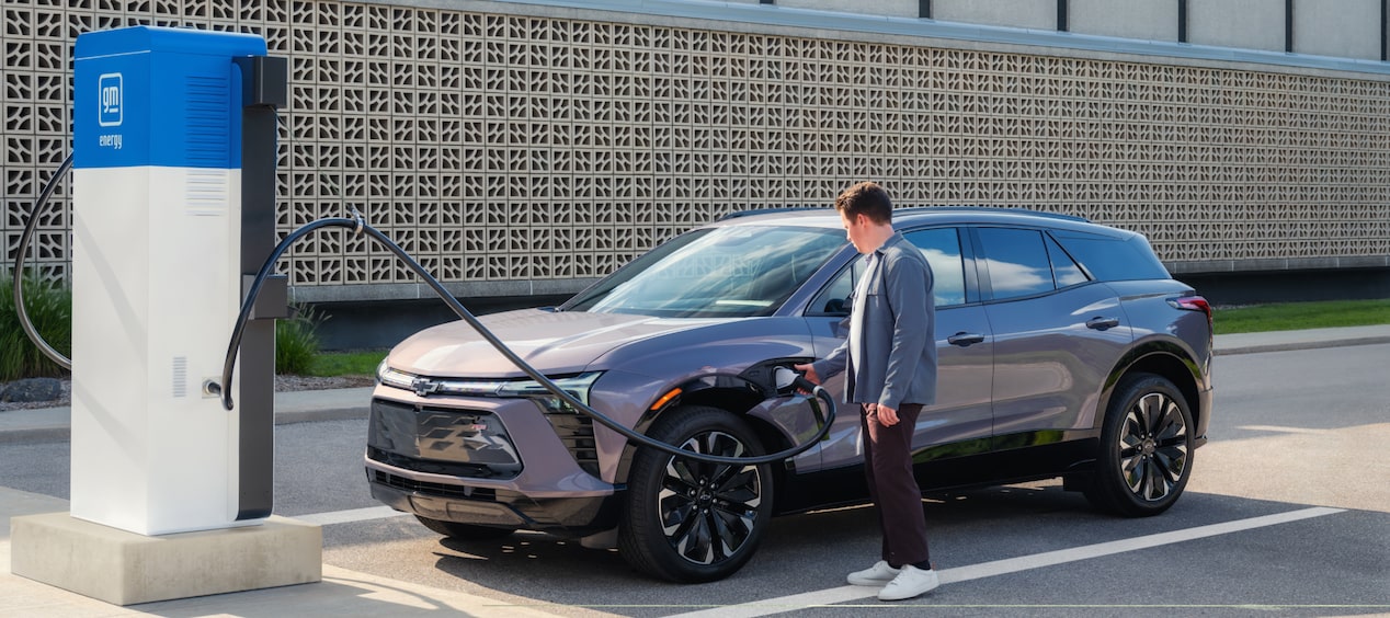 Person Plugging Silver Blazer EV in for a Charge