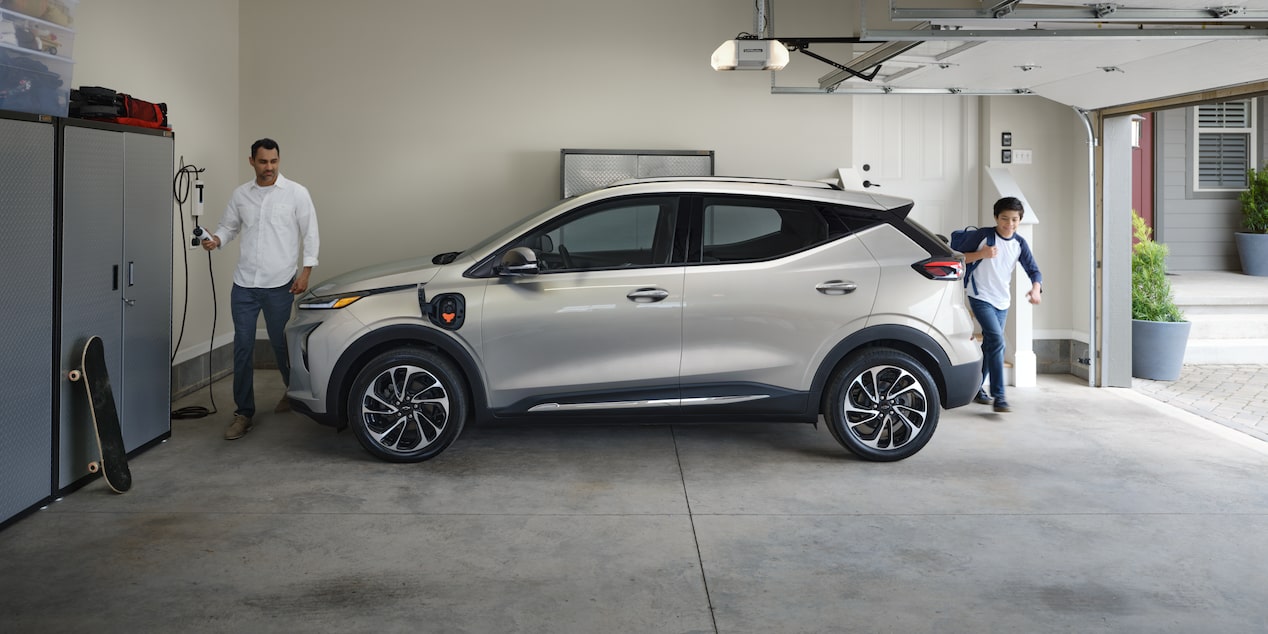 Un hombre conecta su Chevy Bolt EUV en el garaje de su casa