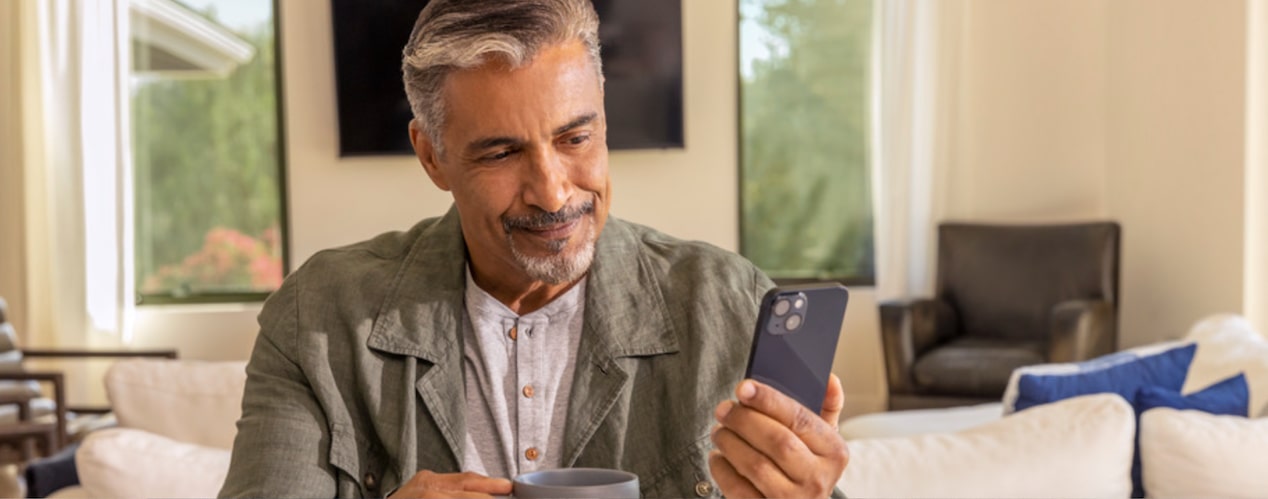 A Man Using His MyChevrolet App on His Smartphone at Home