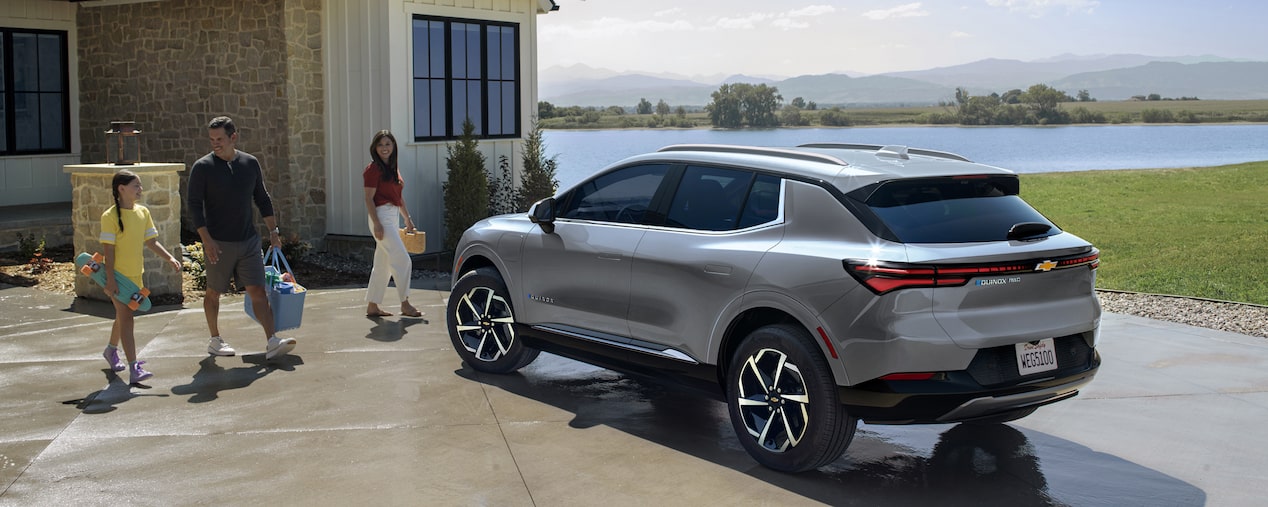 Chevy Equinox EV en una entrada para vehículos con una familia