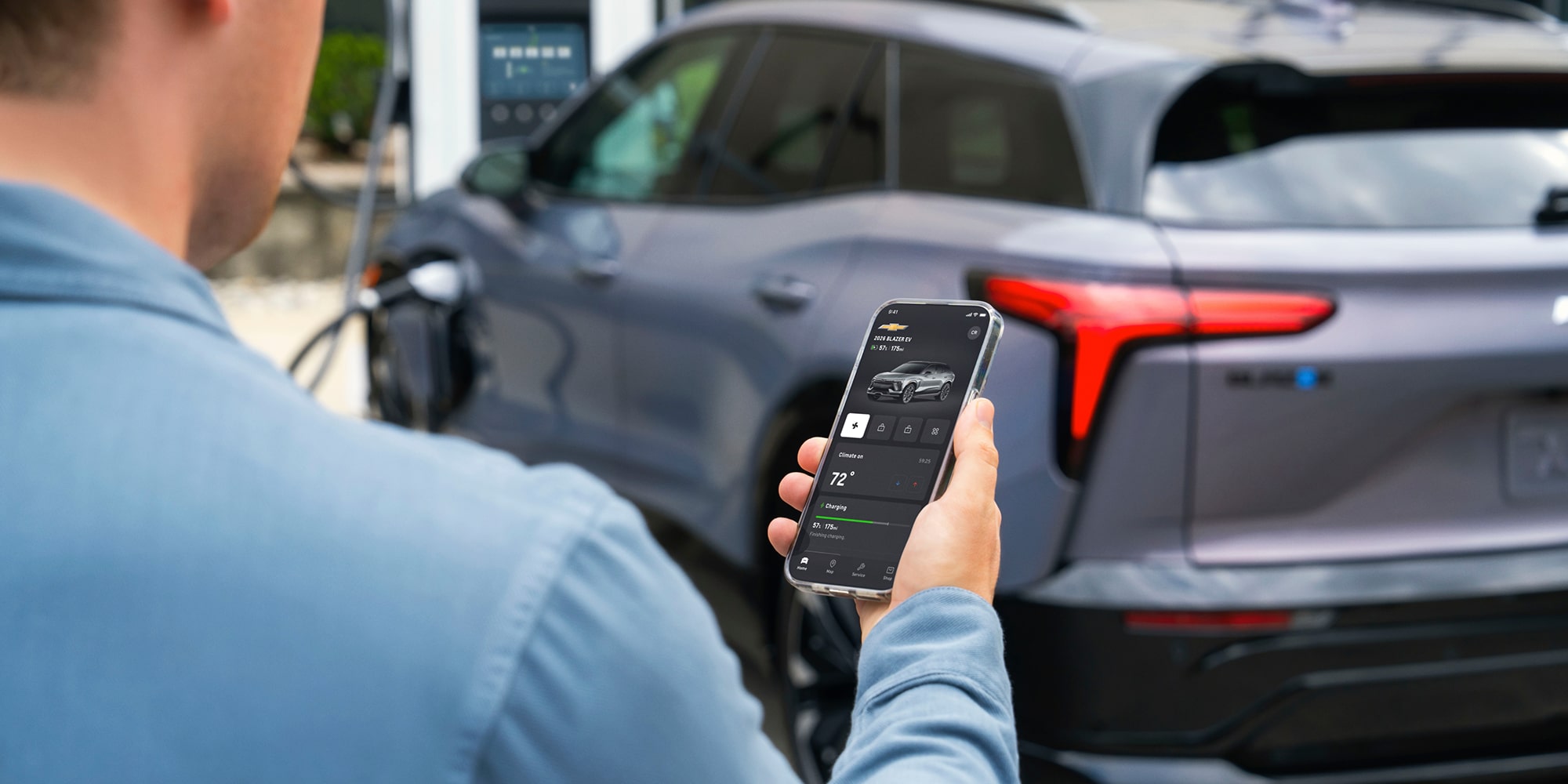 Person Using Mobile Phone Next to Charging Blazer EV