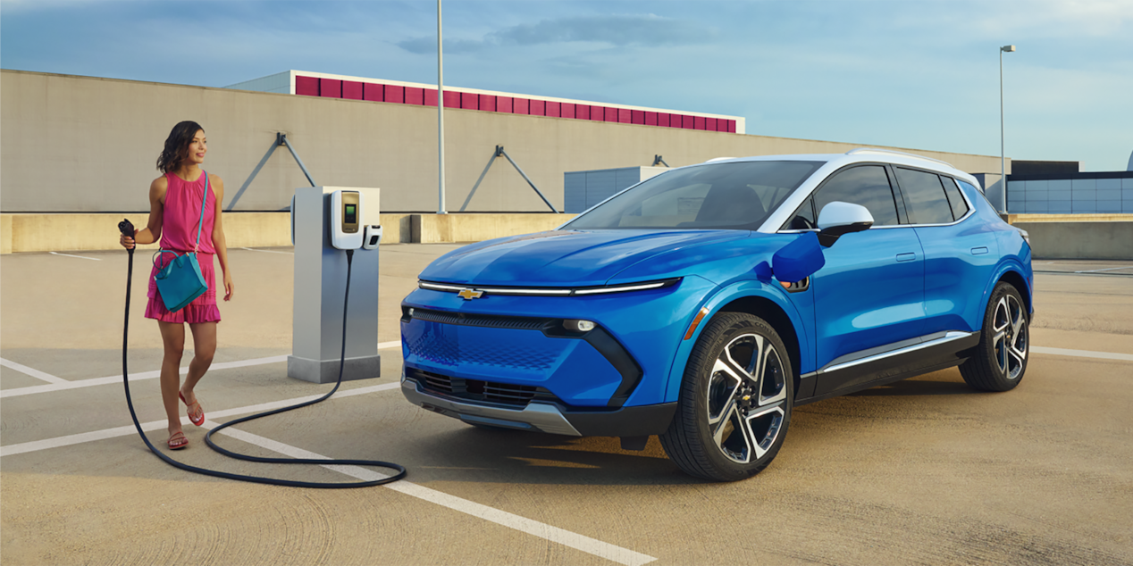 Woman Charging her 2024 Chevy Equinox EV at a Public Charging Station