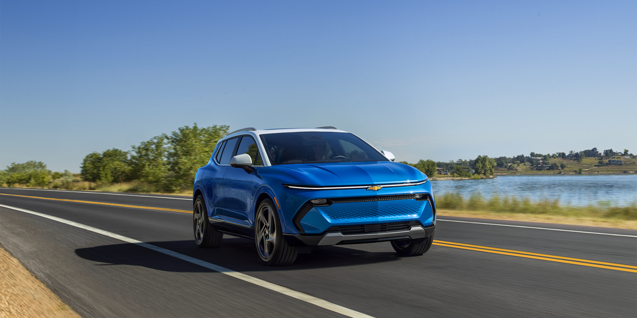 2024 Chevy Equinox EV Driving on a Road Next to Lake
